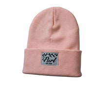 Pink beanie with a patch on a black background